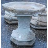 A reconstituted stone birdbath, of hexagonal form with acanthus leaf decoration, on hexagonal base,