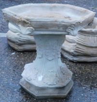 A reconstituted stone birdbath, of hexagonal form with acanthus leaf decoration, on hexagonal base,