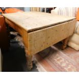 A Victorian stripped pine drop leaf kitchen table.