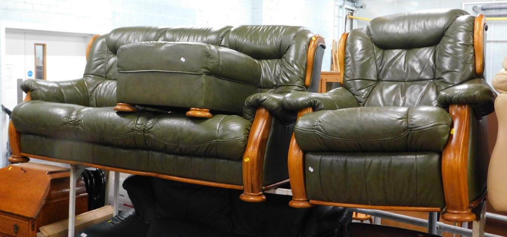 A light green leather three seater sofa, reclining armchair and footstool with wood. The upholstery