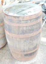 A coopered wooden barrel, 90cm high, 55cm diameter.