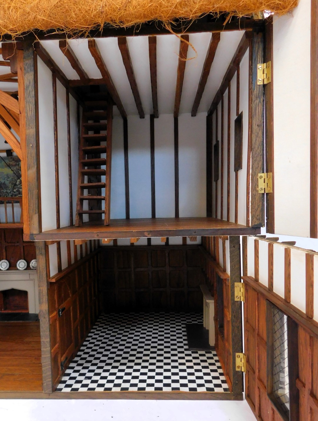 A three storey substantial Tudor style doll's house, with three chimneys, thatched roof, in painted - Image 4 of 10