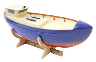 A kit built wooden rowing boat, painted in blue and red, 62cm wide.