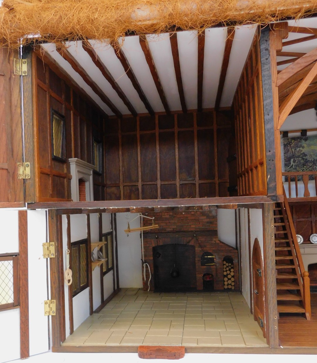 A three storey substantial Tudor style doll's house, with three chimneys, thatched roof, in painted - Image 6 of 10