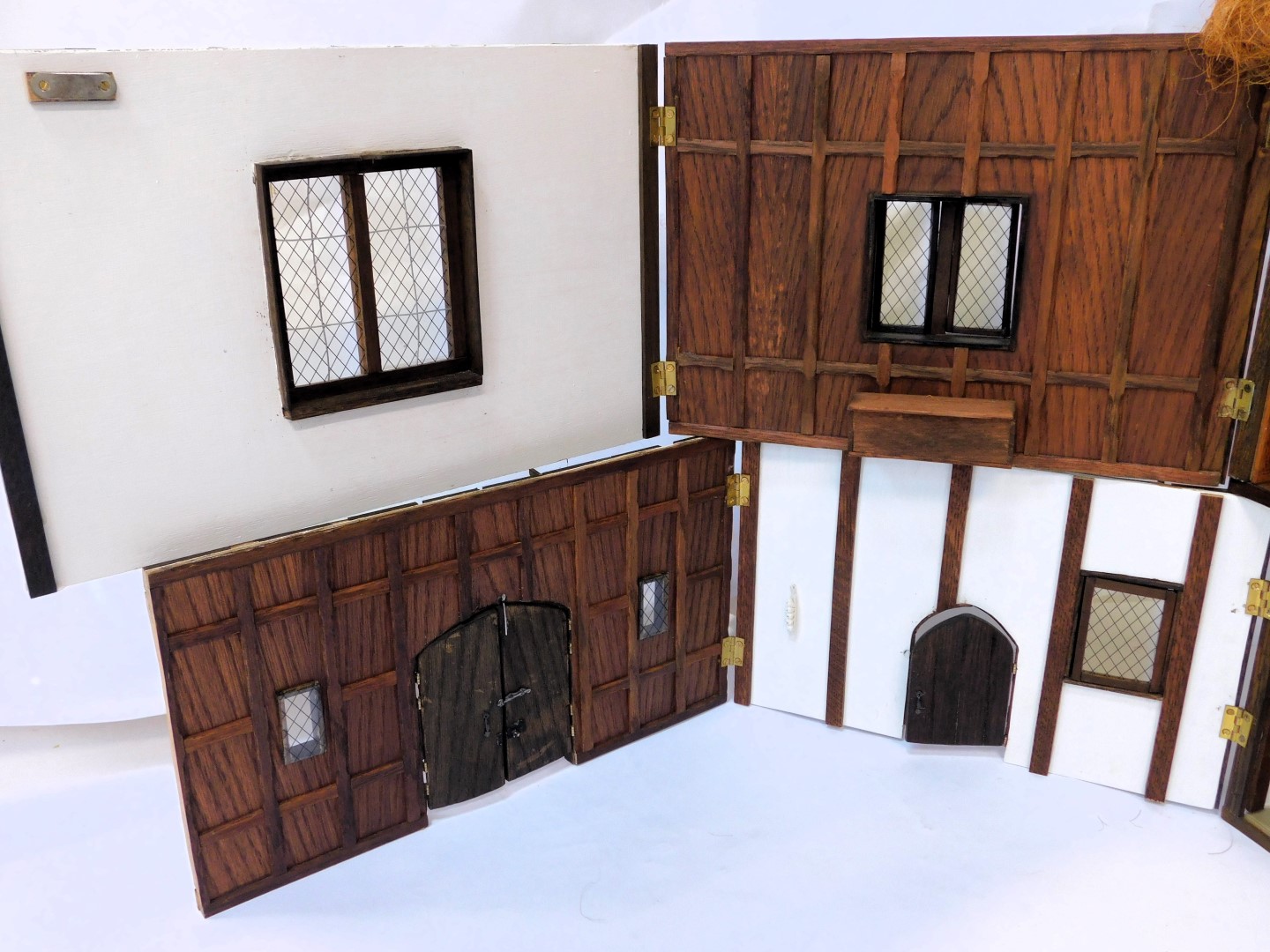 A three storey substantial Tudor style doll's house, with three chimneys, thatched roof, in painted - Image 8 of 10