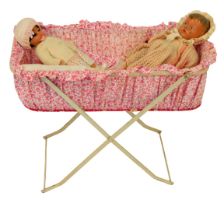 An early 20thC doll's crib, on a cream painted metal base, with floral surround, and two doll's, to