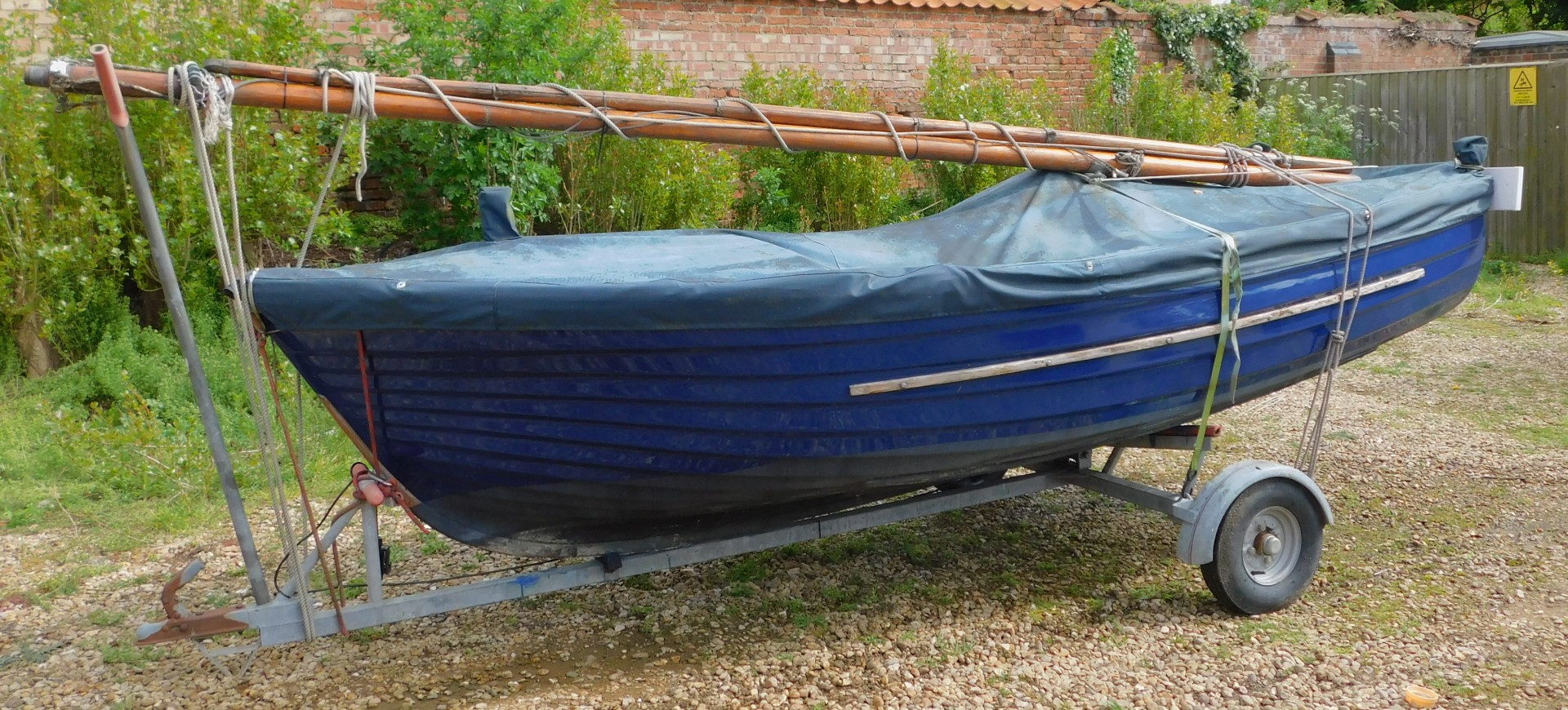 A 12ft blue G.R.P Clinker Sailing Dingy, with a mahogany gunwale with brass fittings, with Neil Pryd