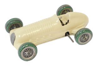 A Mettoy clockwork tinplate racing car, on a cream ground with black and green spoked tyres and wind