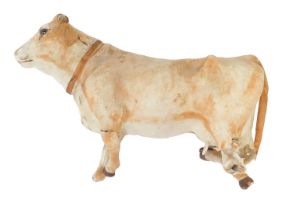 A papier mache and cow hide cow, 38cm wide. (AF)