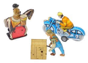 Three tinplate toys, comprising a motorbike and racer, a British drummer on horseback, and a New Yor