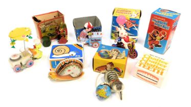 A group of clockwork tinplate toys, to include snail, cat and ball, talking teeth, cat mowing the la