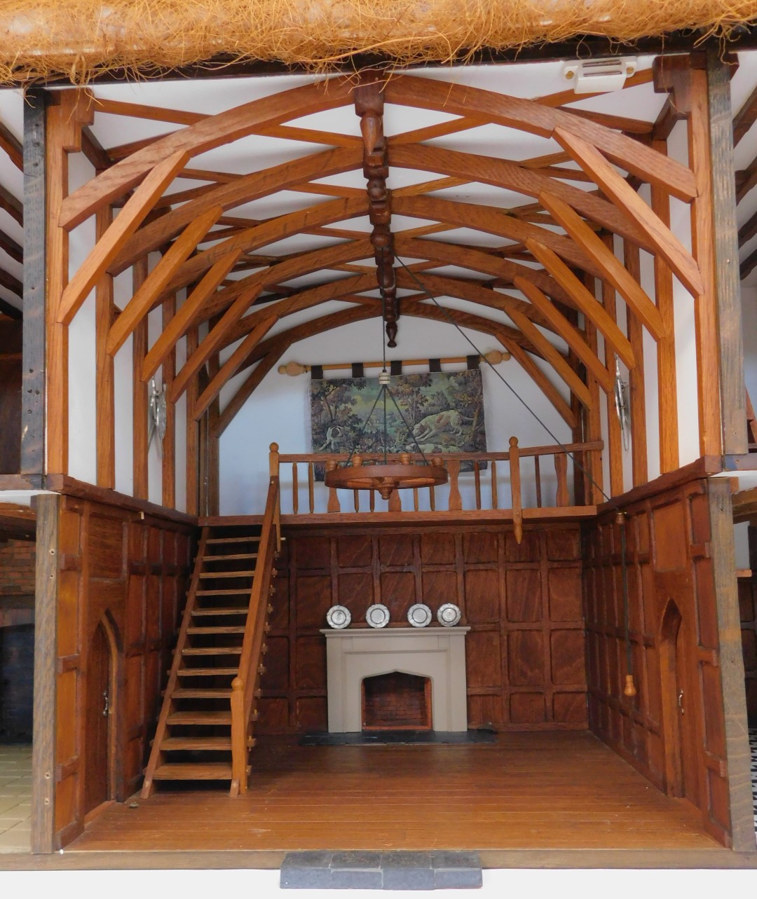 A three storey substantial Tudor style doll's house, with three chimneys, thatched roof, in painted - Image 5 of 10