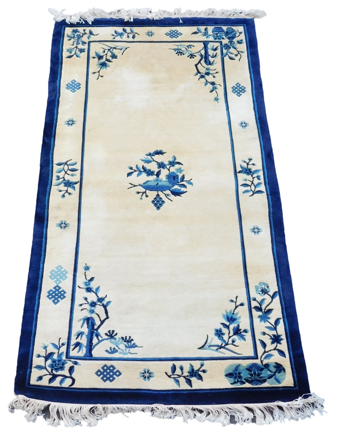 A Chinese blue and cream ground rug, decorated with flowers and blossom, 187cm x 94cm.