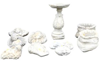 A group of concrete garden ornaments, including cherubs and a lion's head, together with a pair of p