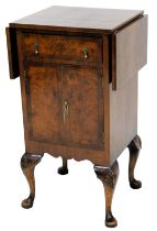 A walnut side cabinet, the rectangular cross banded top with two drop leaves, above a drawer and two