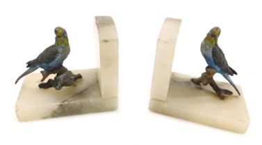 A pair of early 20th cold painted metal and onyx book ends, modelled with a pair of budgerigars, eac