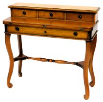 A French fruitwood writing table, the raised back with three frieze drawers, above a hinged writing