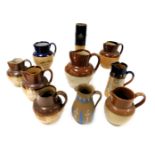 A group of Doulton Lambeth and other stoneware two tone harvest jugs, a chine decorated jug, sprig m