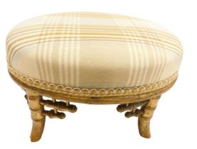 A Victorian gilt wood footstool, in the Japanese taste, with an overstuffed striped seat, raised on