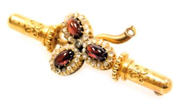A Victorian Etruscan style red cabochon and diamond set bar brooch, of three leaf form, yellow metal