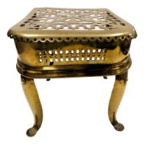 A 19thC brass footman, with a pierced top and sides, raised on a cast iron frame with a pair of bras