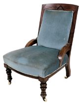 A late Victorian walnut nursing chair, with a blue upholstered padded back and seat, on turned legs