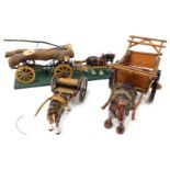 Three pottery cart horses, with wooden carts, one for tree trunk carrying, on a green rectangular ba
