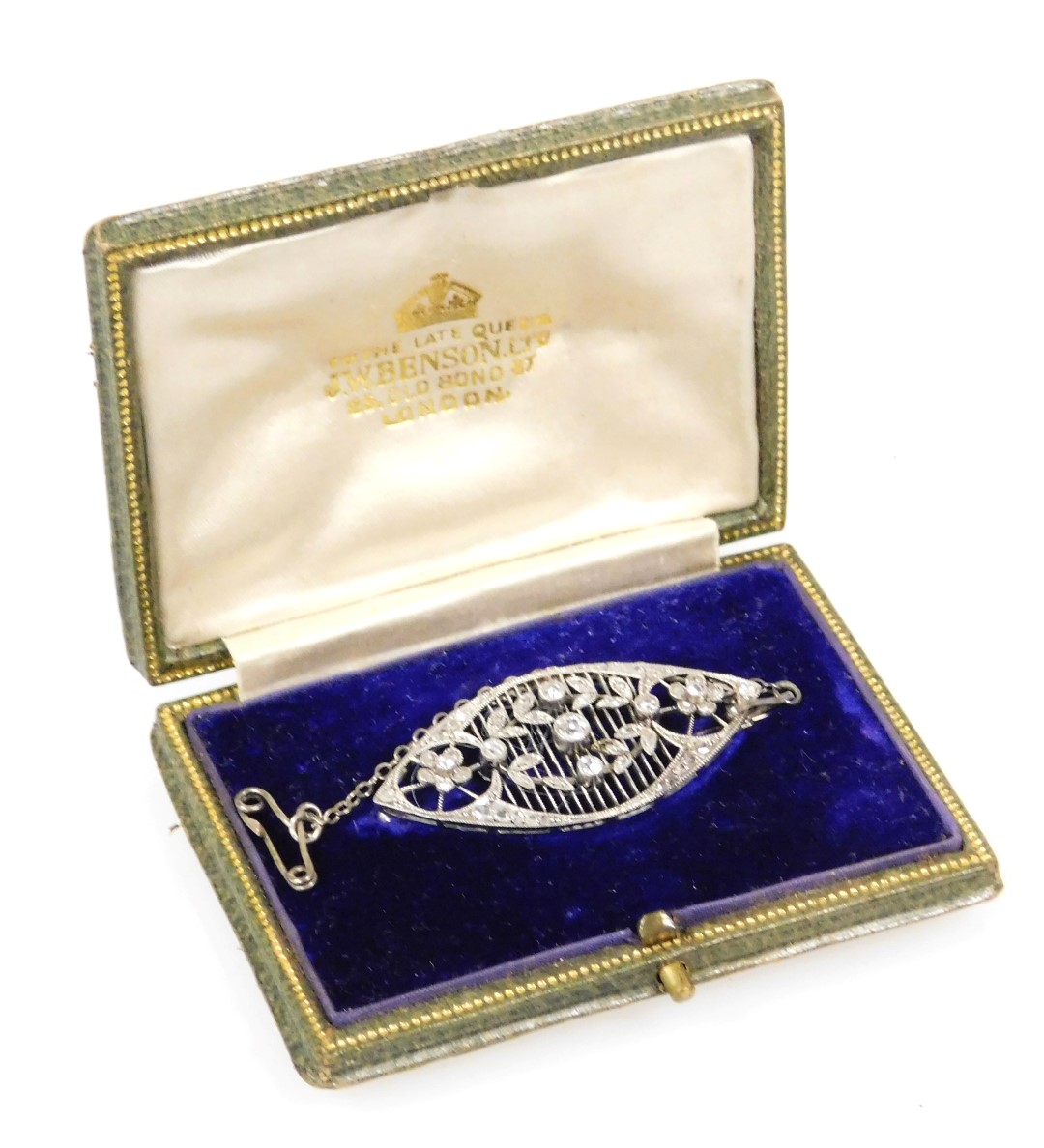 An Edwardian diamond set brooch, in a lozenge openwork design, with a central wreath flanked by two