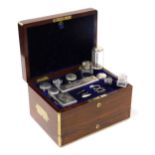 A Victorian rosewood and brass bound travelling box, the hinged lid opening to reveal a purple velve