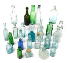 A group of Victorian and later blue and green glass bottles, including Scrubbs fluid, a bottle for W