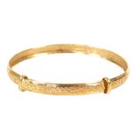 A 9ct gold child's bangle with embossed decoration, 2.0g.