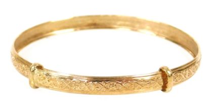 A 9ct gold child's bangle with embossed decoration, 2.0g.