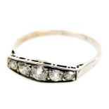 An early 20thC diamond five stone ring, channel set in white metal, approximately ¼ct, size M, 1.1g
