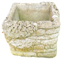 A square reconstituted stone planter of brick form.