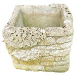 A square reconstituted stone planter of brick form.