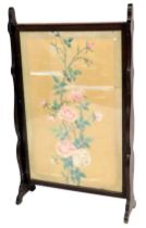 An Edwardian mahogany fire screen, with a rectangular silk banner, painted with flowers in a Chinese