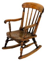 A 19thC child's ash and elm rocking chair, with spindle turned back, shaped arms and turned legs.