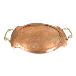 A late 19thC Arts and Crafts copper and brass twin handled tray, with hammered and engraved floral d