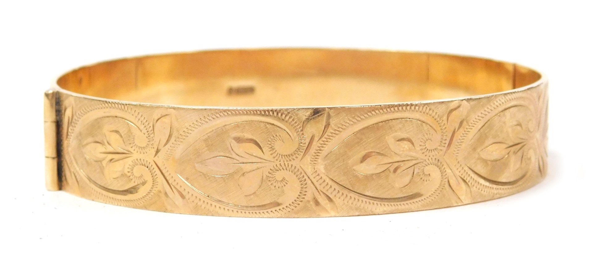 A 9ct gold bangle, with engraved repeating acanthus leaf decoration, on a snap clasp, 24.5g.
