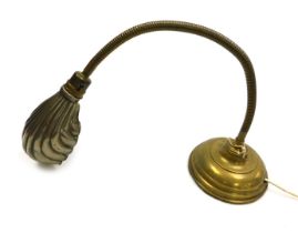 An early 20thC brass anglepoise desk lamp, with a fluted shell shaped shade, on a loaded base.