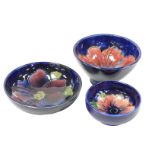 A group of Moorcroft pottery, comprising three bowls decorated in the Hibiscus, Clematis and Anemone