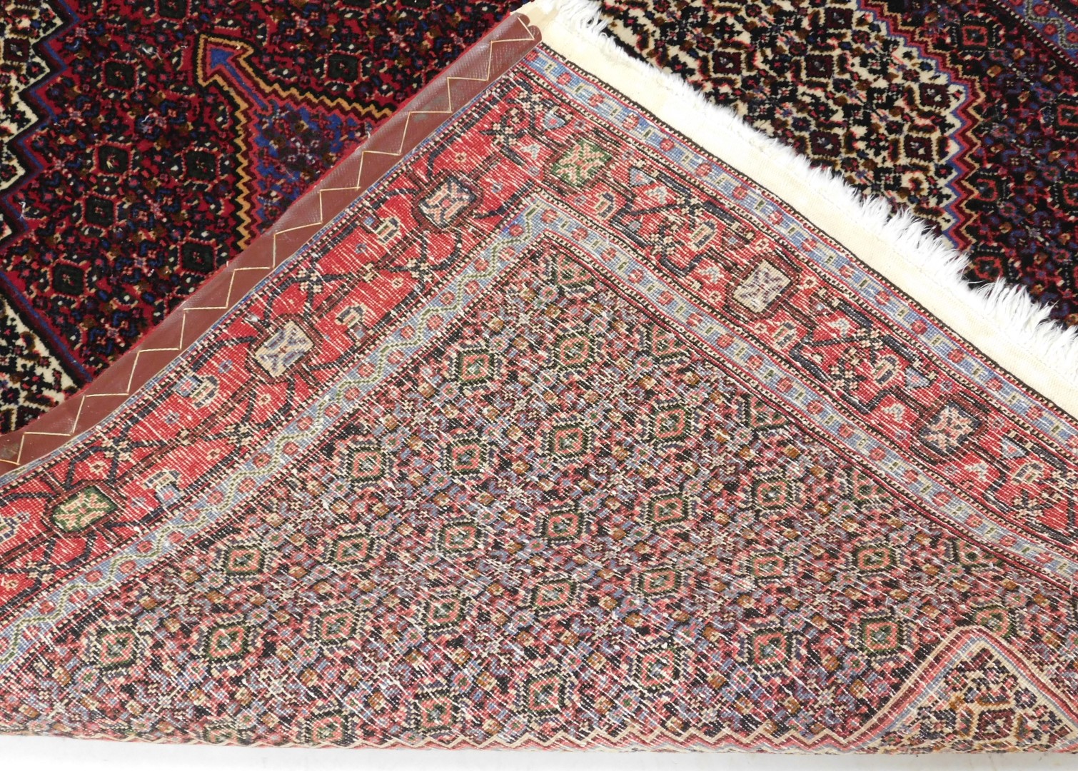 A Persian rug with a central medallion, surrounded by geometric motifs in red, cream pink and blue, - Image 3 of 3