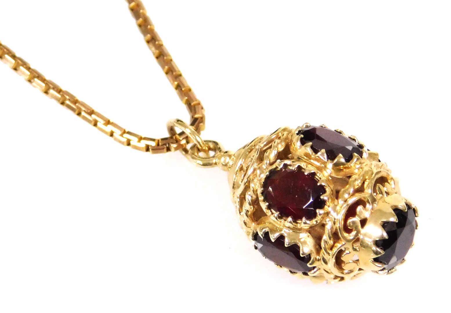 A 9ct gold and garnet pendant, of Turkish lantern form, on a 9ct gold box link neck chain, with bolt