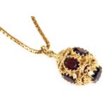 A 9ct gold and garnet pendant, of Turkish lantern form, on a 9ct gold box link neck chain, with bolt