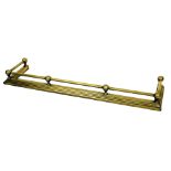 An early 20thC brass fire curb or fender, with tubular rail and fluted tapering base, 133cm wide.