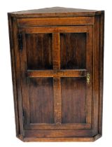 A late 18th/early 19thC hanging corner cabinet, single panelled door, iron H hinges, 105cm high, 70c