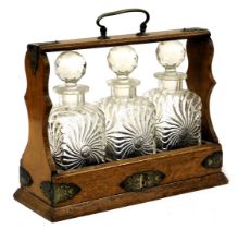 A Victorian oak and silver plated tantalus, with three cut glass decanters and stoppers, no key, 35.