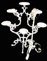 A cast iron cream painted stand, with a set of six pierced plateaus, each for garden urns, etc., on