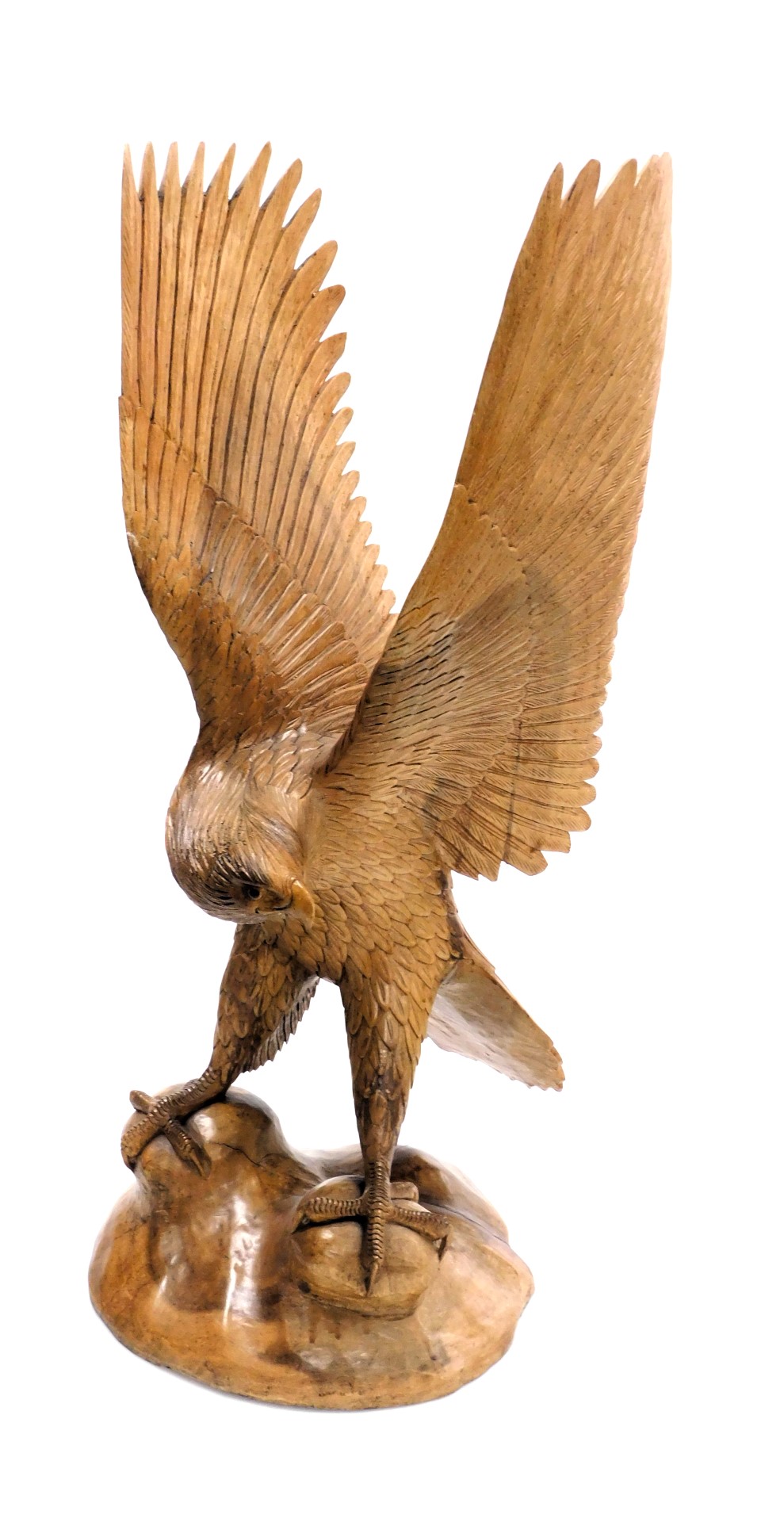 A wooden carved figure of an eagle, its wings aloft, raised on a naturalistic base, 78cm high.