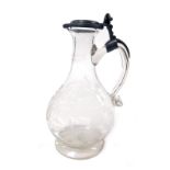 A 19thC cut glass flagon, with a hinged pewter lid, of pear shaped form, engraved with stylised flow